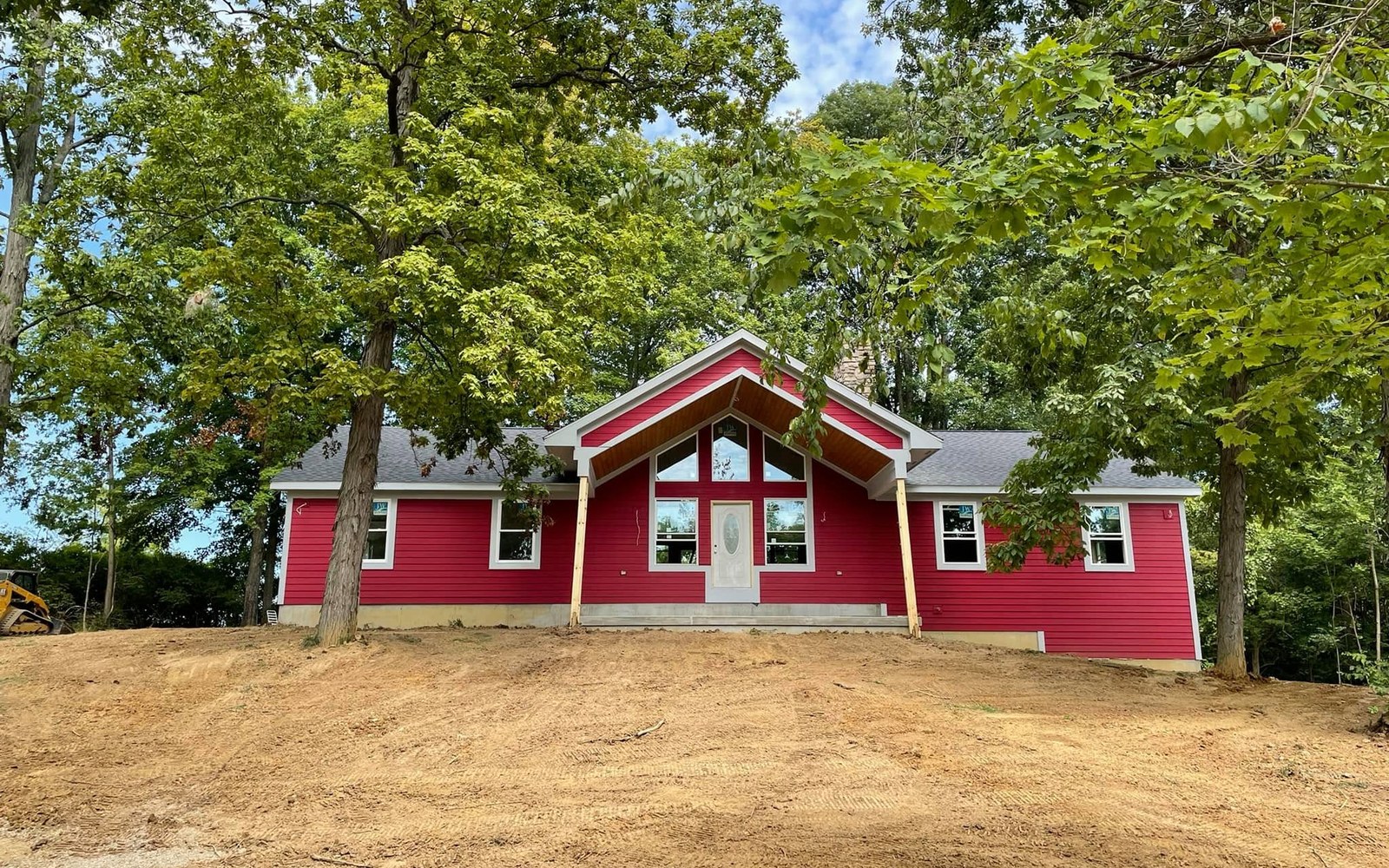 Red home on a freshly graded wooded building site