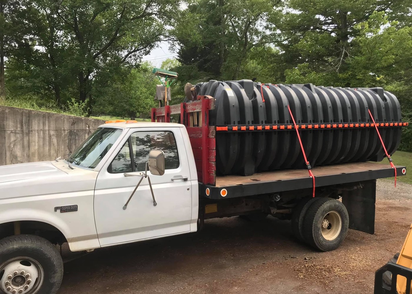 Large black septic tank secured on a work truck
