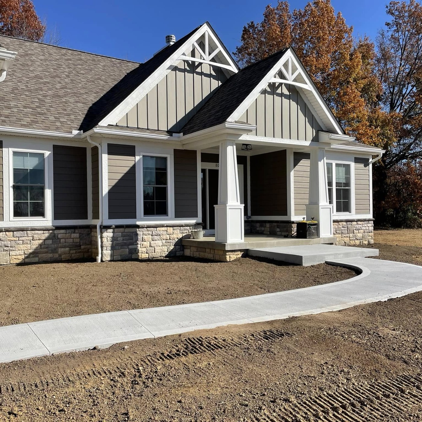 Completed home entry with a curved concrete approach and fresh grade