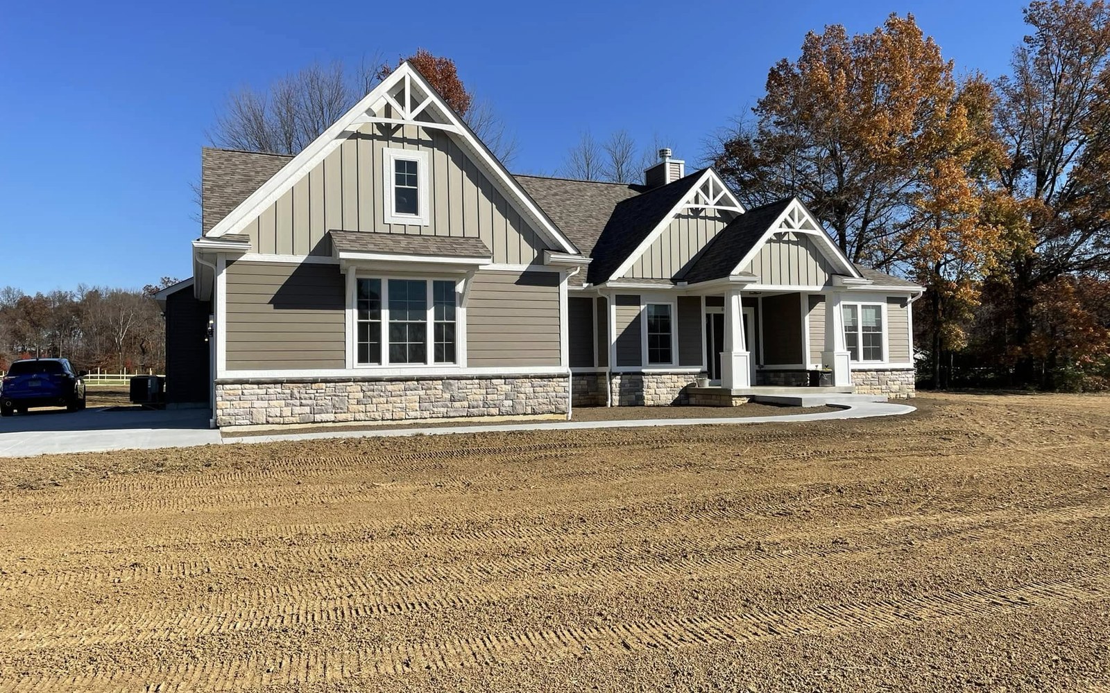 Completed taupe home with freshly graded front yard